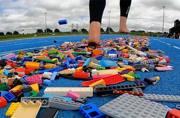 300 кг LEGO під ногами: мама побила рекорд найшвидшого забігу босоніж деталями — фото